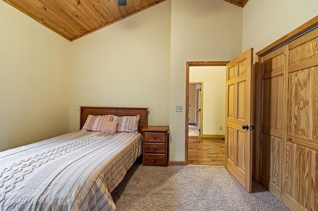 carpeted bedroom featuring a closet, wood ceiling, high vaulted ceiling, and baseboards