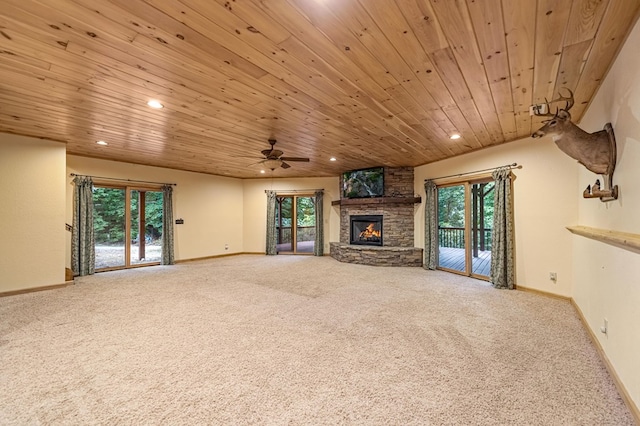 unfurnished living room featuring carpet floors, wood ceiling, a stone fireplace, and recessed lighting