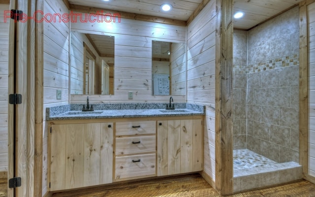 bathroom with double vanity, wooden walls, and a sink