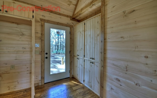 entryway with wood finished floors and wood walls