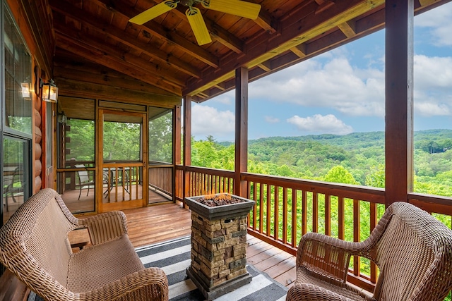 sunroom / solarium with ceiling fan, plenty of natural light, and lofted ceiling with beams