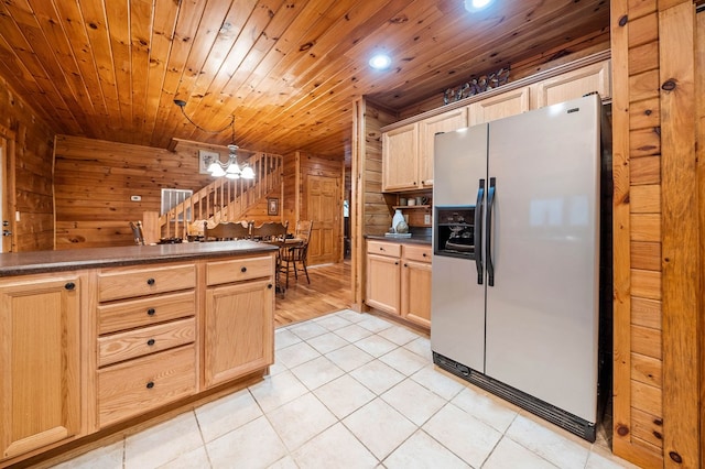 kitchen with wooden walls, stainless steel fridge with ice dispenser, and light brown cabinets