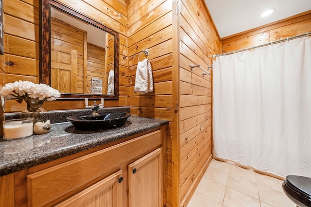 bathroom with vanity, tile patterned flooring, and wooden walls