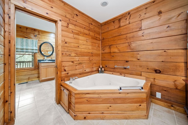 bathroom with tile patterned floors, vanity, wood walls, and a bath