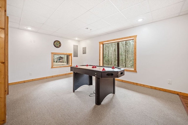 recreation room featuring carpet floors, electric panel, and a drop ceiling