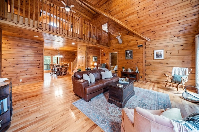 living room with wood ceiling, wooden walls, light hardwood / wood-style floors, and ceiling fan