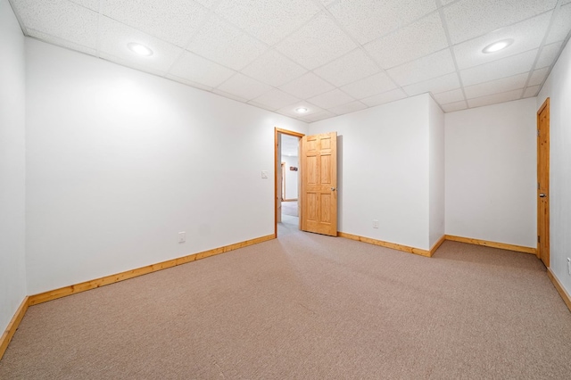 carpeted spare room with a paneled ceiling