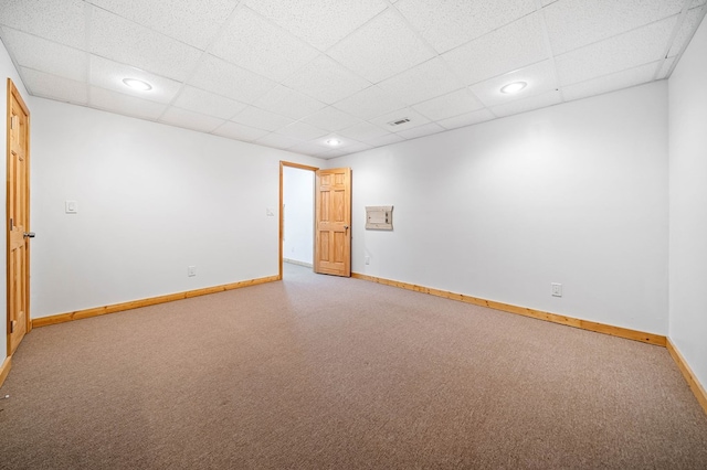 carpeted empty room with a paneled ceiling