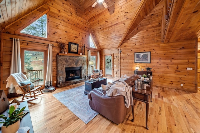 living room featuring a fireplace, light hardwood / wood-style flooring, wood ceiling, and wood walls