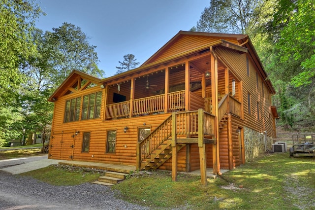 back of house featuring ceiling fan, faux log siding, stairway, and central AC