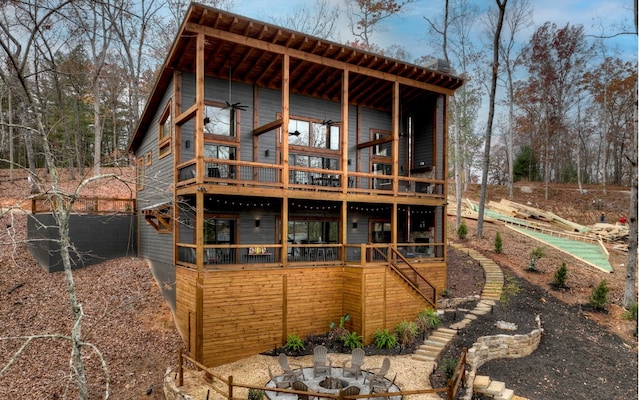 back of house with a fire pit and a wooden deck