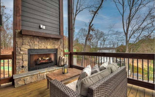 wooden deck featuring an outdoor stone fireplace