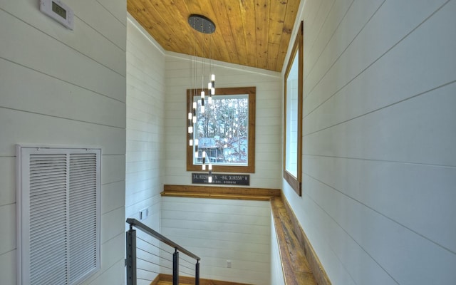 interior space with wood ceiling, vaulted ceiling, plenty of natural light, and wood walls