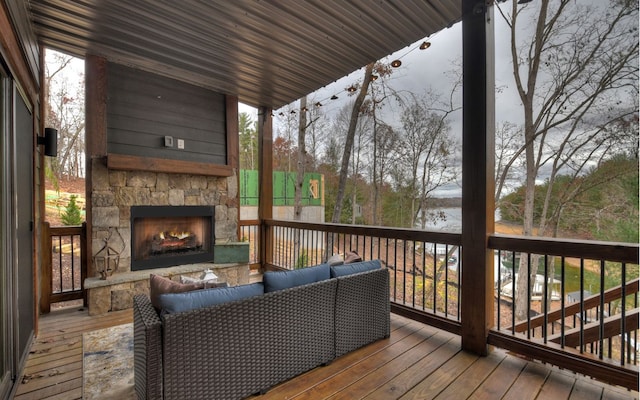 deck with a water view and an outdoor living space with a fireplace