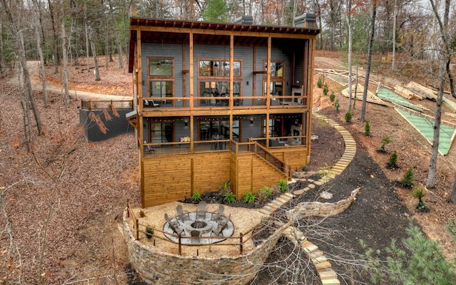 back of house featuring a fire pit and a swimming pool