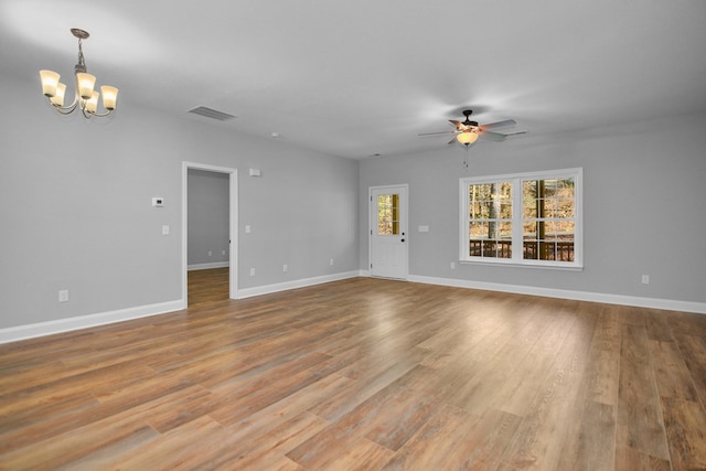 unfurnished room featuring ceiling fan with notable chandelier and light wood-type flooring