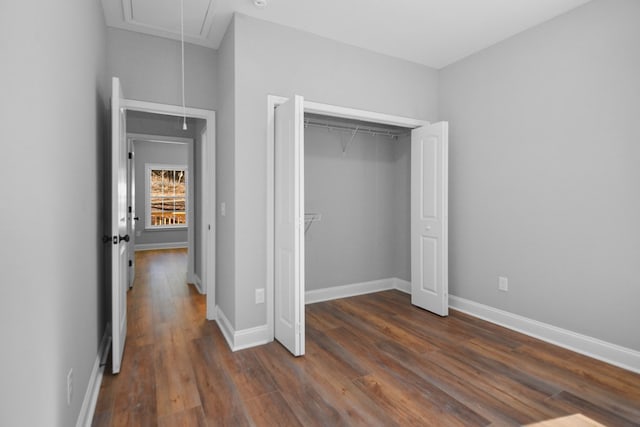 unfurnished bedroom featuring dark hardwood / wood-style floors and a closet