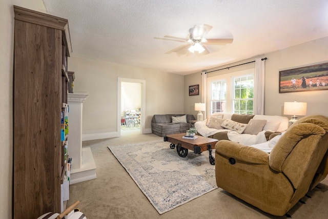 living room with light carpet, a textured ceiling, baseboards, and a ceiling fan
