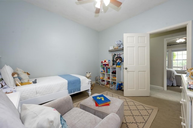 bedroom featuring a ceiling fan, light carpet, baseboards, and lofted ceiling