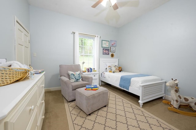 bedroom with light colored carpet, ceiling fan, and baseboards