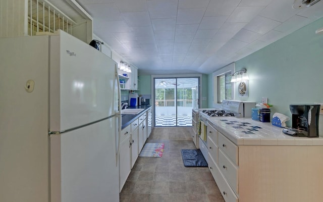 30 Proctor St, Murphy, NC 28906 - kitchen with freestanding refrigerator, tile countertops, white cabinets, and range