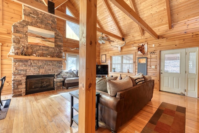 living room with a fireplace, light hardwood / wood-style flooring, wooden ceiling, and wooden walls