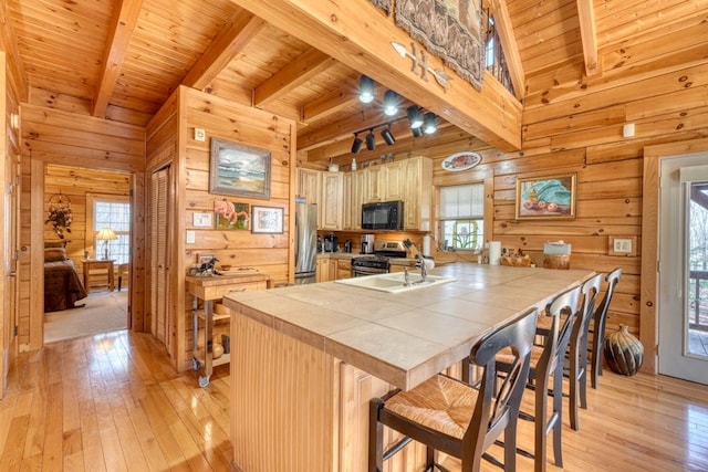 kitchen with wood walls, tile countertops, stainless steel appliances, and wood ceiling