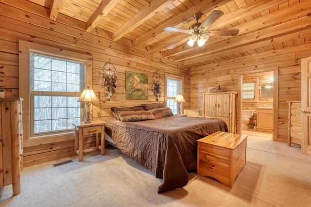 carpeted bedroom featuring connected bathroom, ceiling fan, wooden ceiling, wooden walls, and beam ceiling