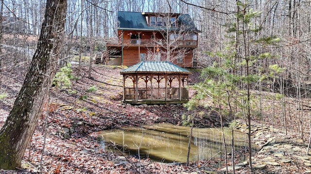 rear view of property with a water view and a gazebo