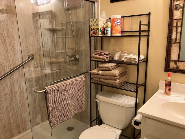 bathroom with a shower stall, toilet, and vanity
