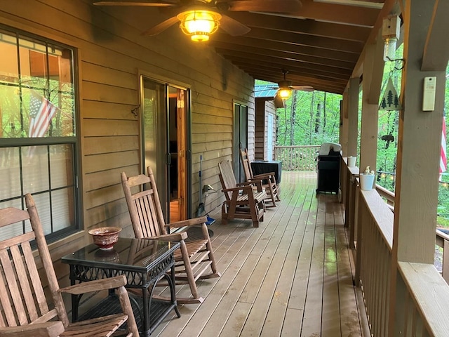 wooden deck with ceiling fan, area for grilling, and covered porch