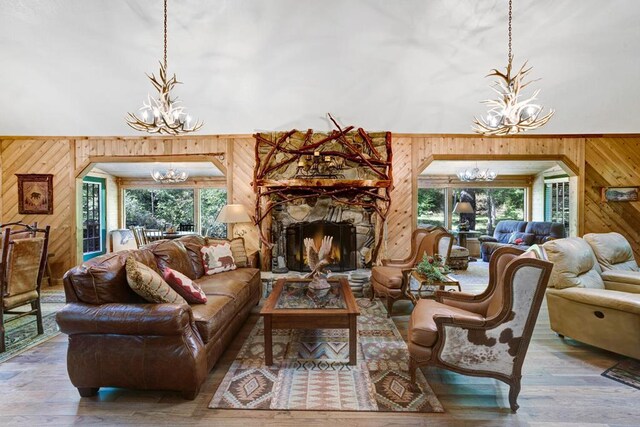 living room featuring an inviting chandelier, wooden walls, and hardwood / wood-style floors