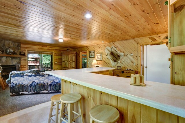 kitchen featuring wood ceiling, wood walls, carpet flooring, a fireplace, and white fridge