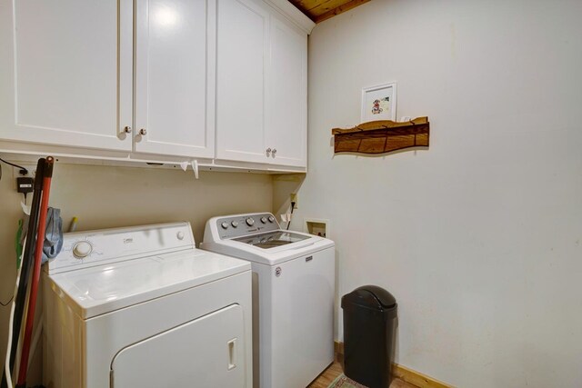 washroom featuring cabinets, light hardwood / wood-style flooring, and washer and clothes dryer