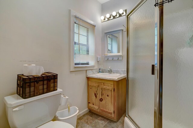 bathroom featuring walk in shower, vanity, and toilet