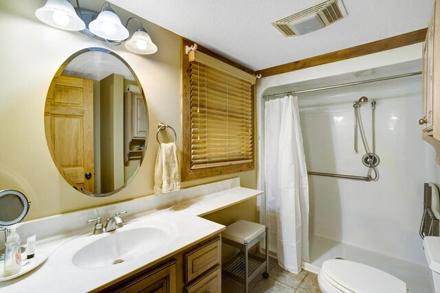 bathroom with tile patterned floors, a shower with curtain, vanity, and toilet