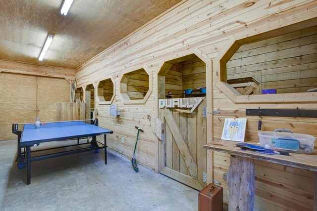 interior space with wood walls and concrete floors