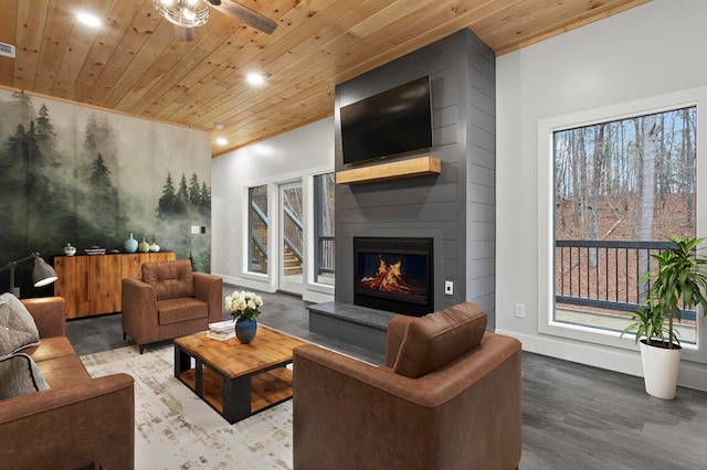 living room with hardwood / wood-style floors, wooden ceiling, a large fireplace, and ceiling fan