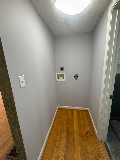 laundry room featuring electric dryer hookup, washer hookup, wood finished floors, baseboards, and laundry area