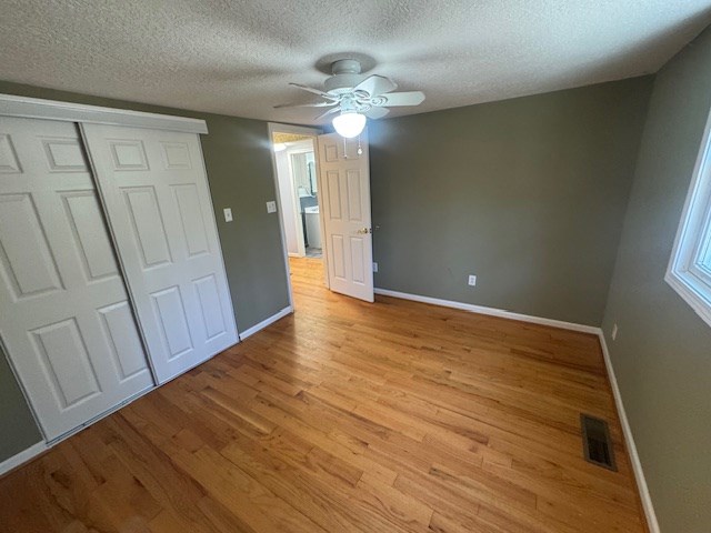 unfurnished bedroom with light wood finished floors, visible vents, and baseboards