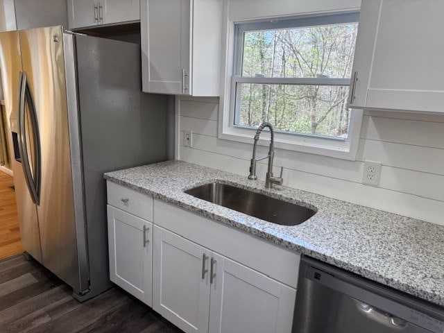 kitchen with white cabinets, stainless steel appliances, dark wood-type flooring, and a sink