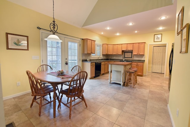 tiled dining room featuring french doors and lofted ceiling