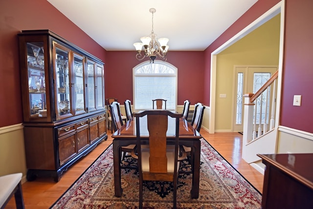 dining space featuring light wood-type flooring and a chandelier