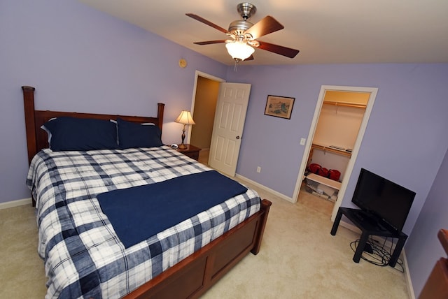 bedroom with ceiling fan, a closet, light carpet, and a spacious closet