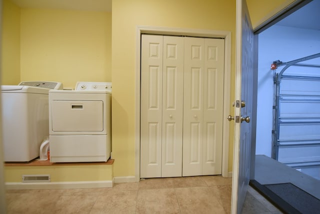 washroom featuring washer and clothes dryer and light tile patterned floors