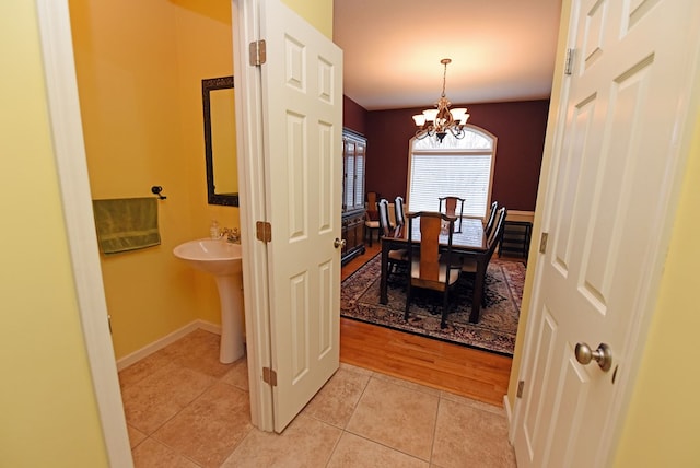 tiled dining area featuring sink and a chandelier