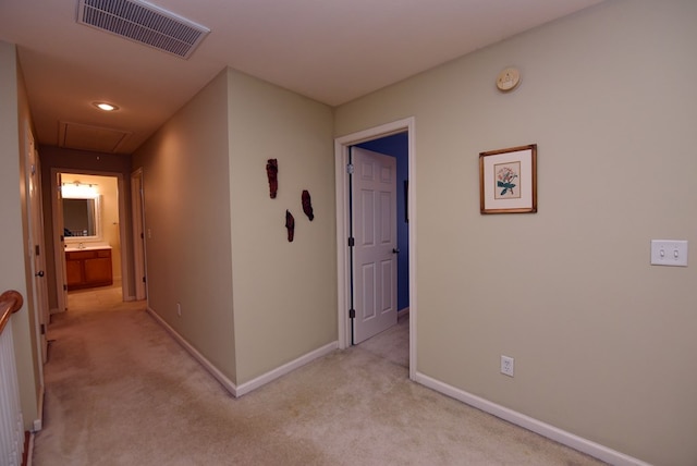 corridor featuring light colored carpet