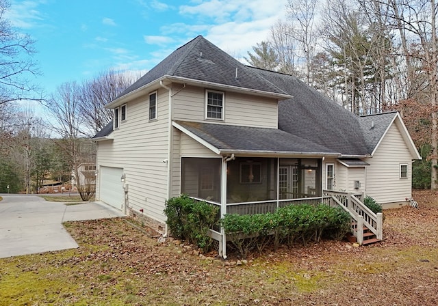 view of side of property featuring a sunroom and a garage