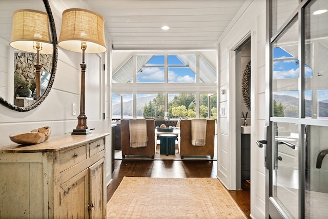 doorway featuring vaulted ceiling, dark wood-style floors, and wooden ceiling