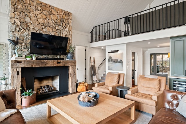 living room featuring wood ceiling, stairs, a fireplace, wood finished floors, and high vaulted ceiling